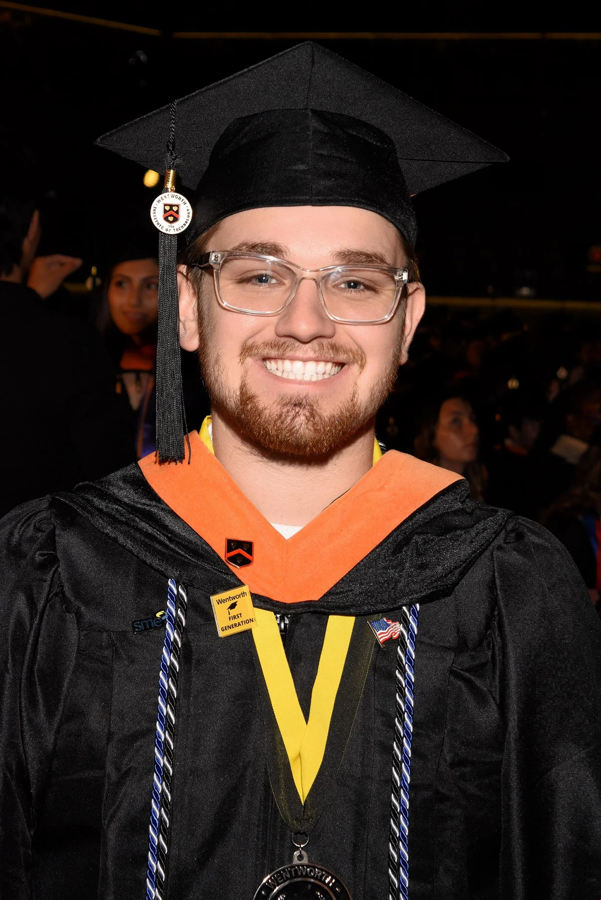 Joshua Hofer smiling in his cap and gown at Wentworth graduation.